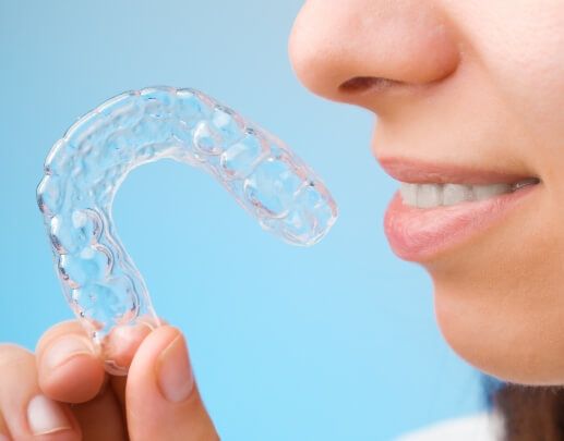 Dental patient holding a Invisalign clear aligner